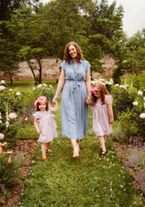 Family Photographer, mother walking with daughters through garden