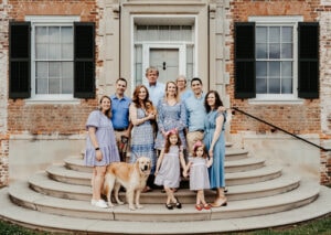Family Photographer, family of 10 with dog standing on steps in front of house