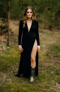 Senior Photographer, woman standing in woods in a black dress