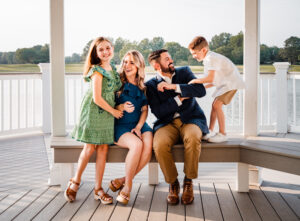 Family Photographer, family playing on white deck by lake