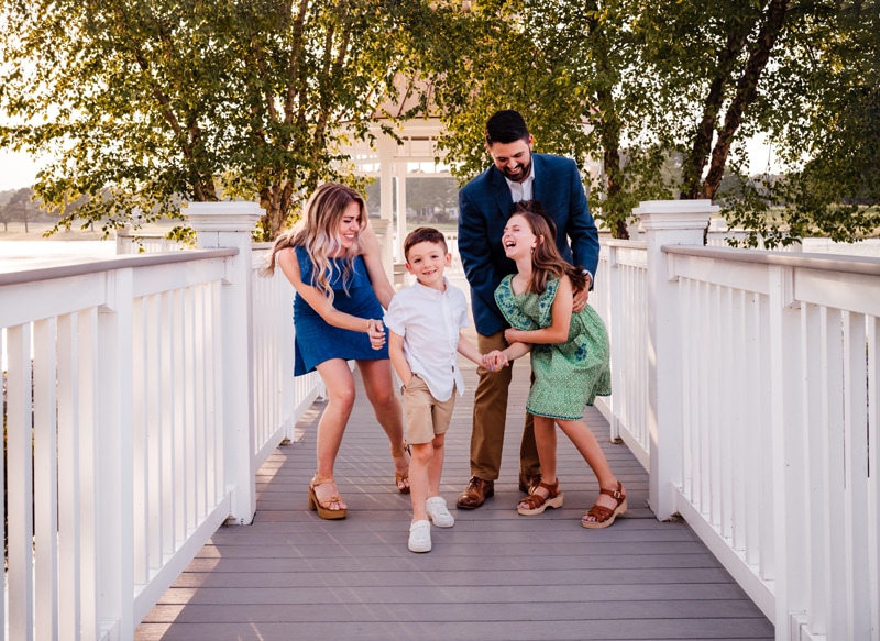 Family Photographer, family of four playing on white bridge