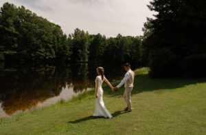 Wedding Photographer, bride and groom walking hand-in-hand by river