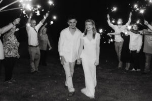 Wedding Photographer, bride and groom walking hand-in-hand with sparklers