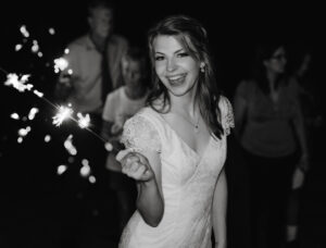 Wedding Photographer, bride smiling holding sparklers