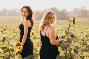 Family Photographer, two women in black dresses standing in sunflower field