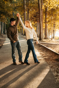 Woman and man twirling on a fall path