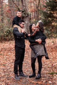 Family photographer, mother and father with son and daughter standing in woods