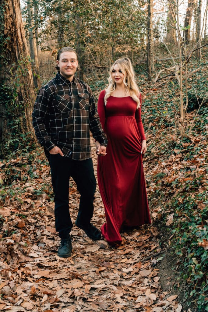 Family photographer, man leading woman through path with leaves
